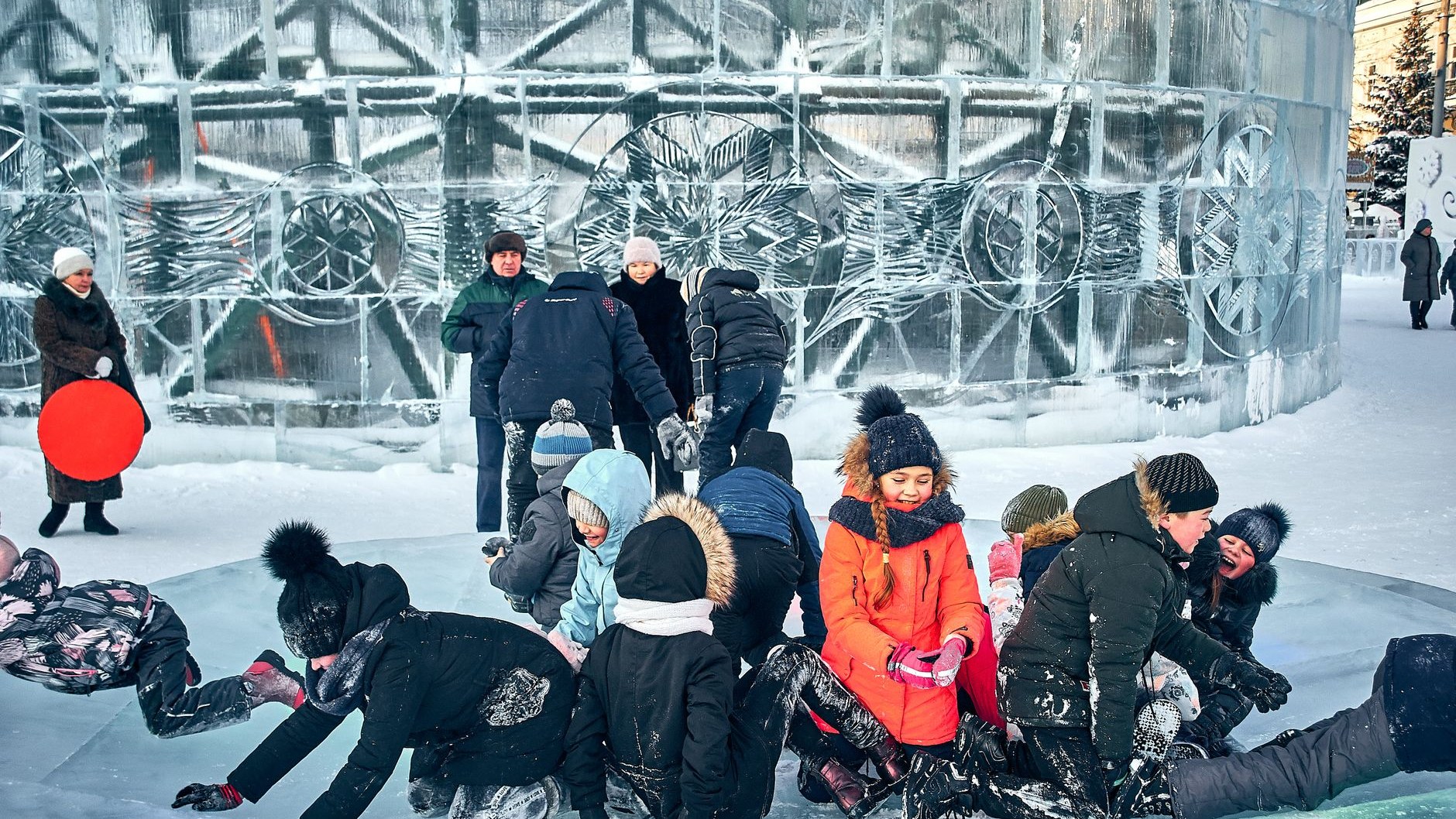 Дети играют в ледовом городке в городском парке зимой