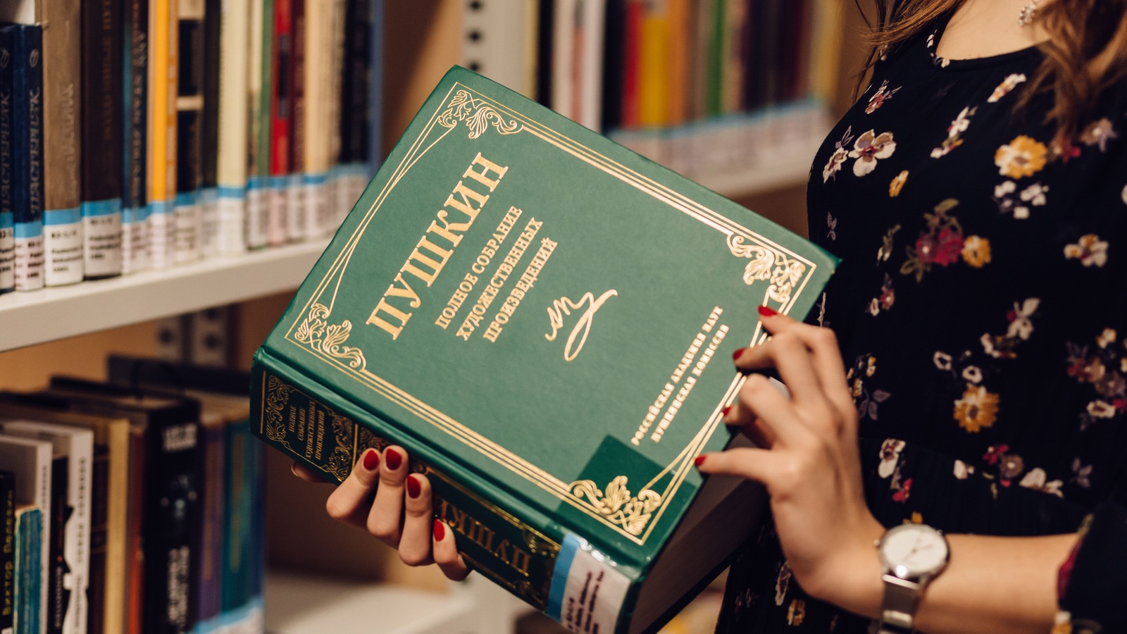 Женщина с книгой Пушкина в библиотеке